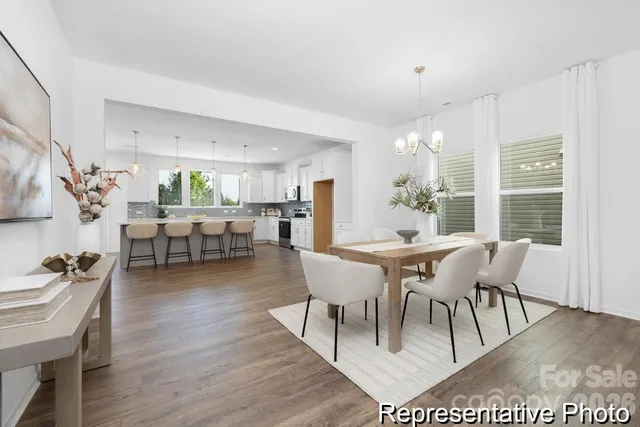 a dining room with furniture potted plants and wooden floor