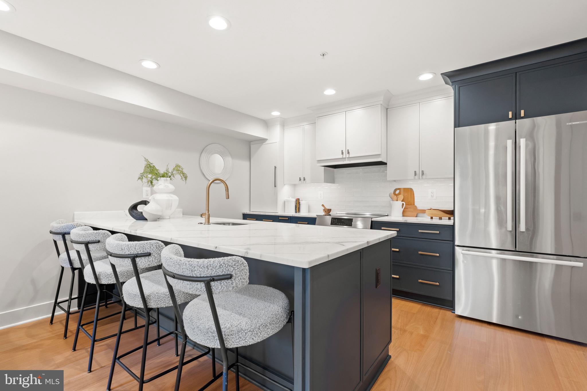 910 9th Street Northeast, Unit 1 Washington, DC 20002 - Photo 12 of 66 a kitchen with stainless steel appliances granite countertop a sink a stove a refrigerator and white cabinets with wooden floor