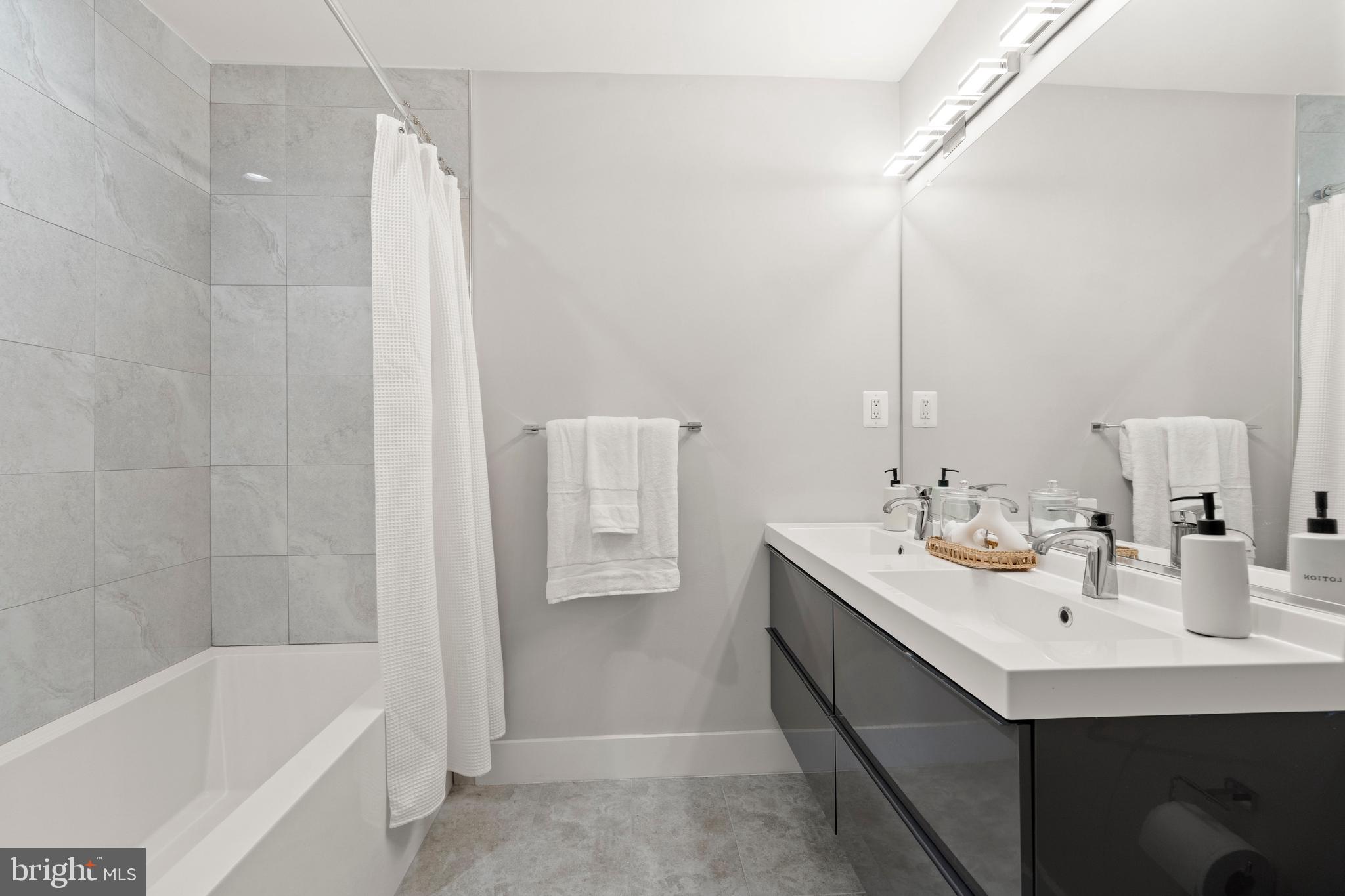 910 9th Street Northeast, Unit 1 Washington, DC 20002 - Photo 27 of 66 a bathroom with a double vanity sink and a bathtub