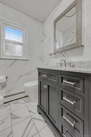 a bathroom with a sink a toilet and mirror