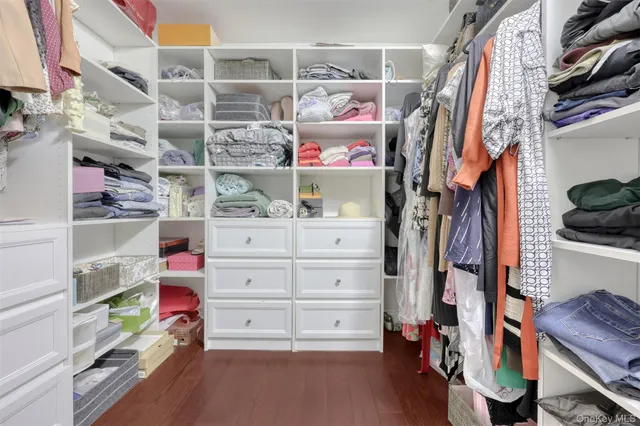 a view of walk in closet with clothes and shoes