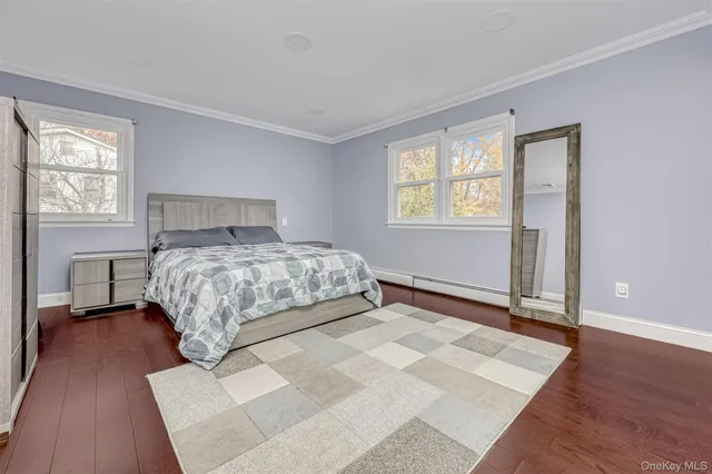 a bedroom with a large bed wooden floor and windows