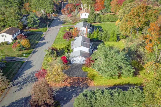 an aerial view of a house with a garden and lake view