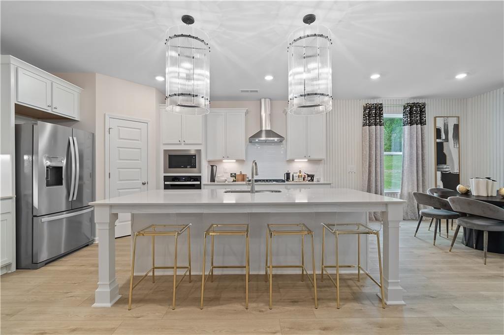 229 Ruthe Cove Locust Grove, GA 30248 - Photo 18 of 56 a kitchen with kitchen island granite countertop a table and chairs in it