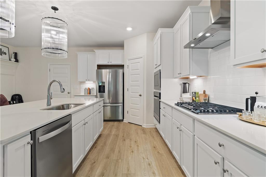 229 Ruthe Cove Locust Grove, GA 30248 - Photo 23 of 56 a kitchen with stainless steel appliances kitchen island granite countertop a sink stove refrigerator and cabinets