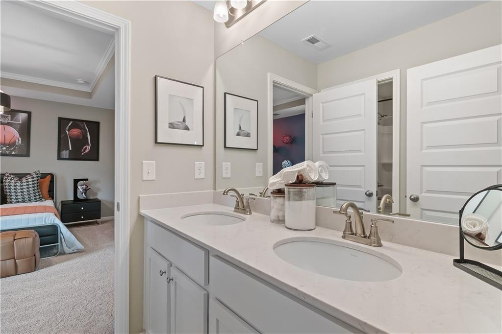229 Ruthe Cove Locust Grove, GA 30248 - Photo 35 of 56 a bathroom with double vanity sinks a vanity and a mirror