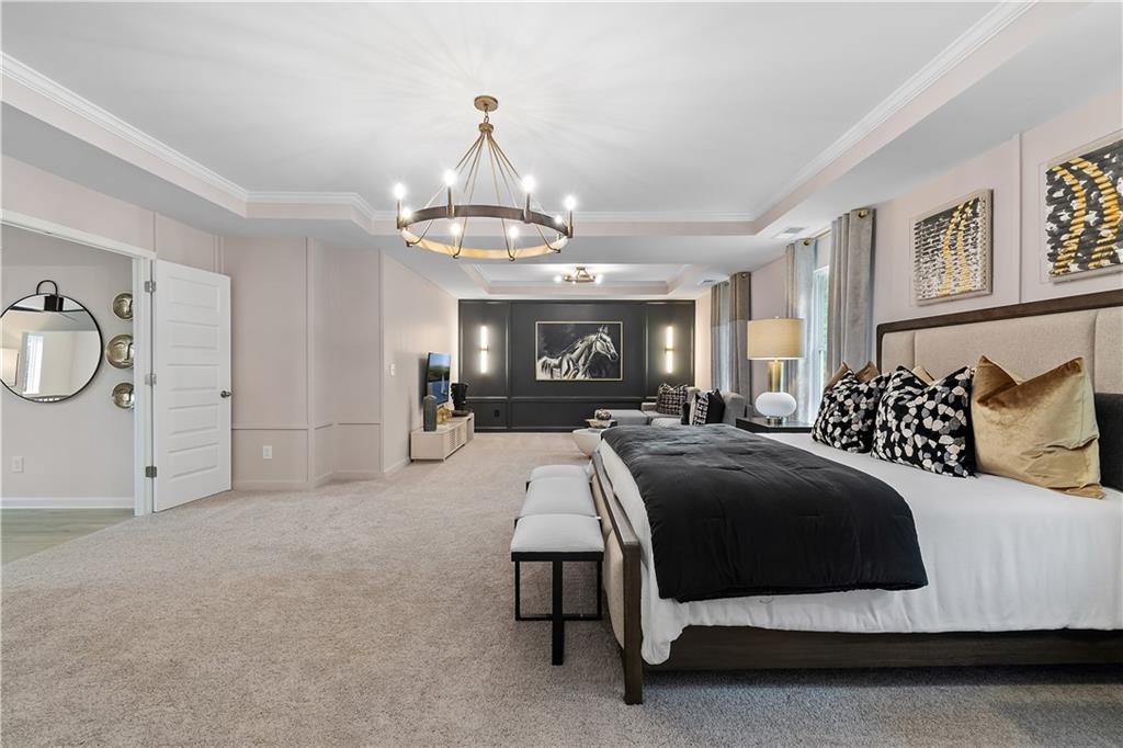 229 Ruthe Cove Locust Grove, GA 30248 - Photo 45 of 56 a spacious bedroom with a bed a chandelier and dresser