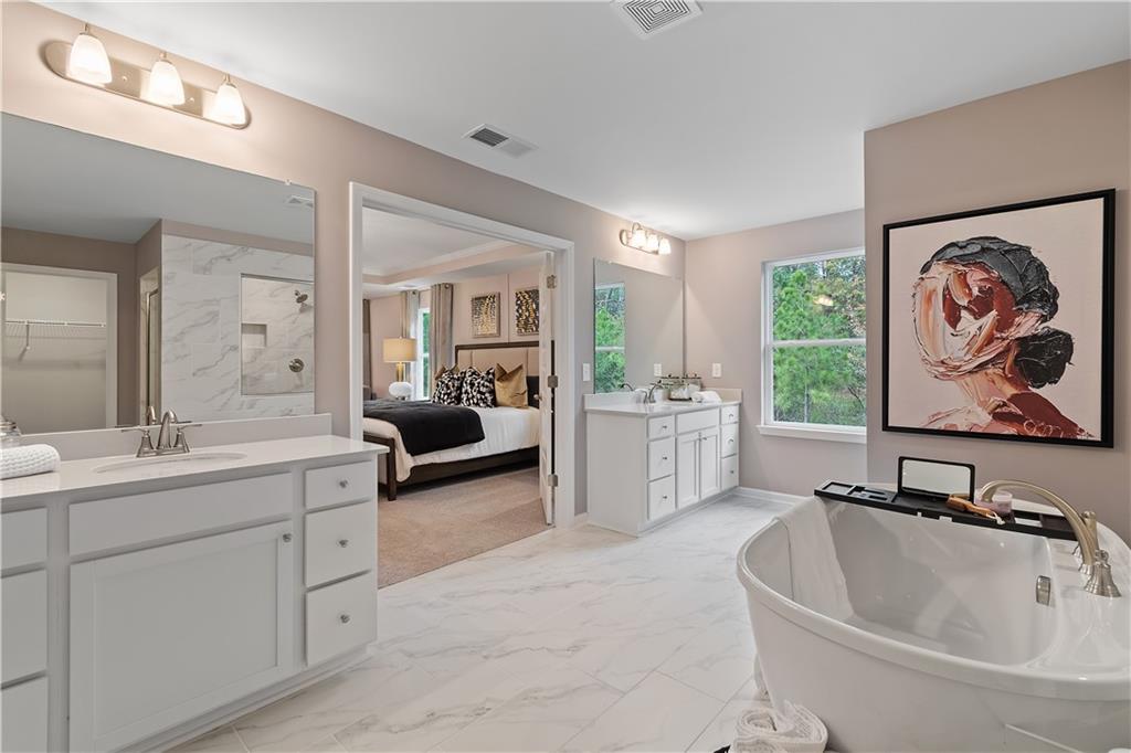 229 Ruthe Cove Locust Grove, GA 30248 - Photo 47 of 56 a bathroom with a double vanity sink a mirror and a bathtub