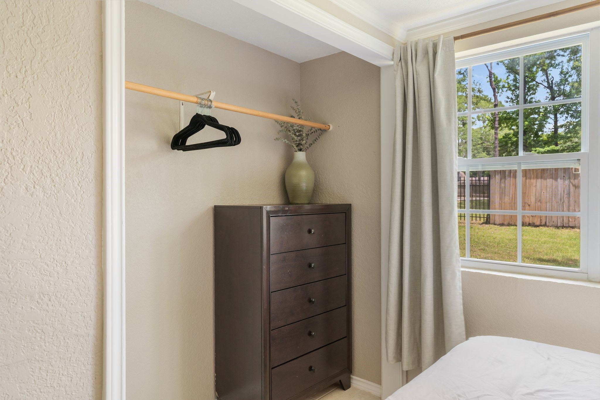 14758 Kirbee Drive Conroe, TX 77302 - Photo 15 of 35 This master bedroom features one of its two inviting closets, offering ample storage and a cozy, sunlit view through a large window.