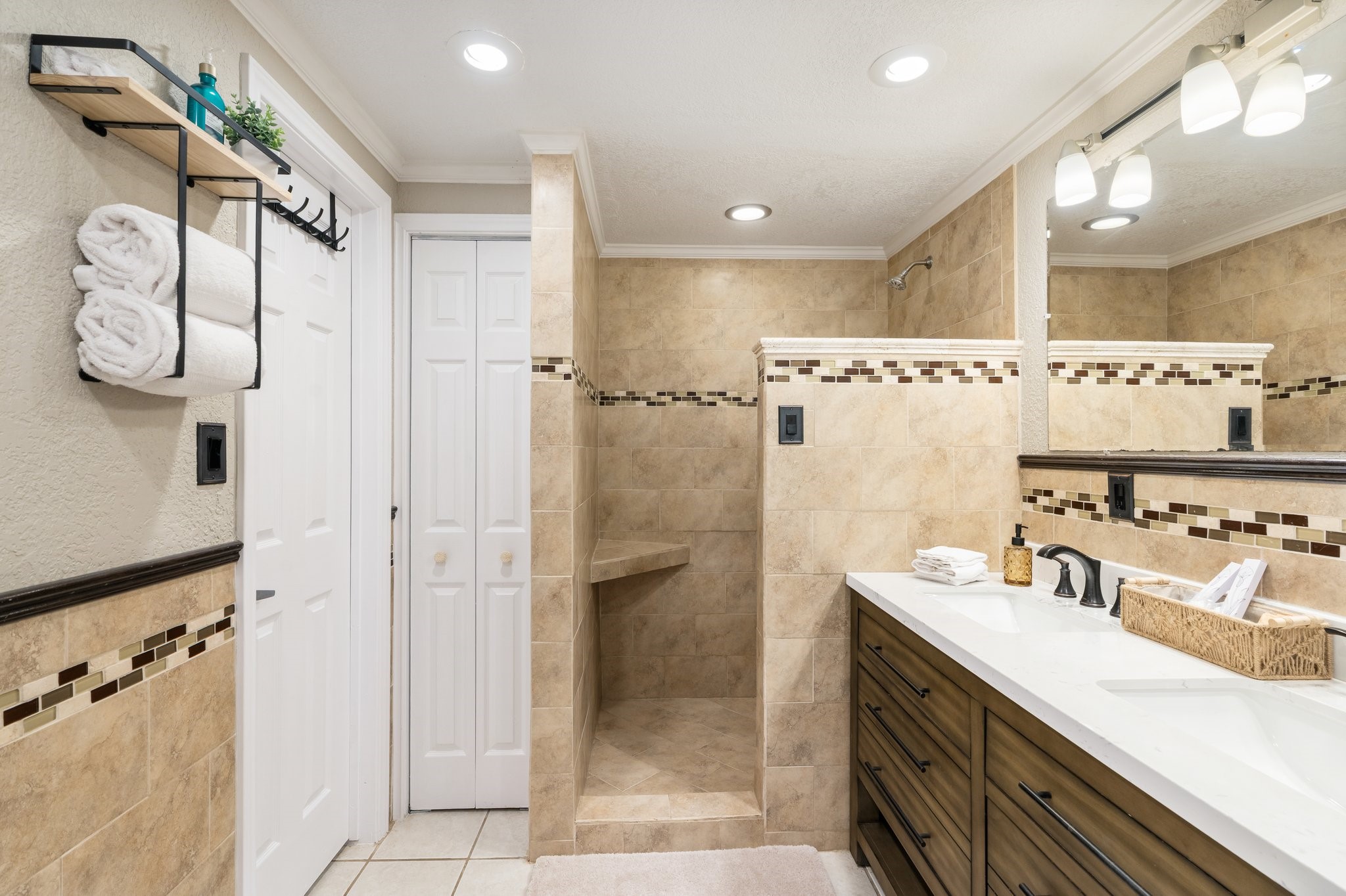 14758 Kirbee Drive Conroe, TX 77302 - Photo 17 of 35 Experience the elegance of the first-floor master bathroom, featuring chic tilework, a spacious walk-in shower, and modern dual vanities for a touch of luxury.