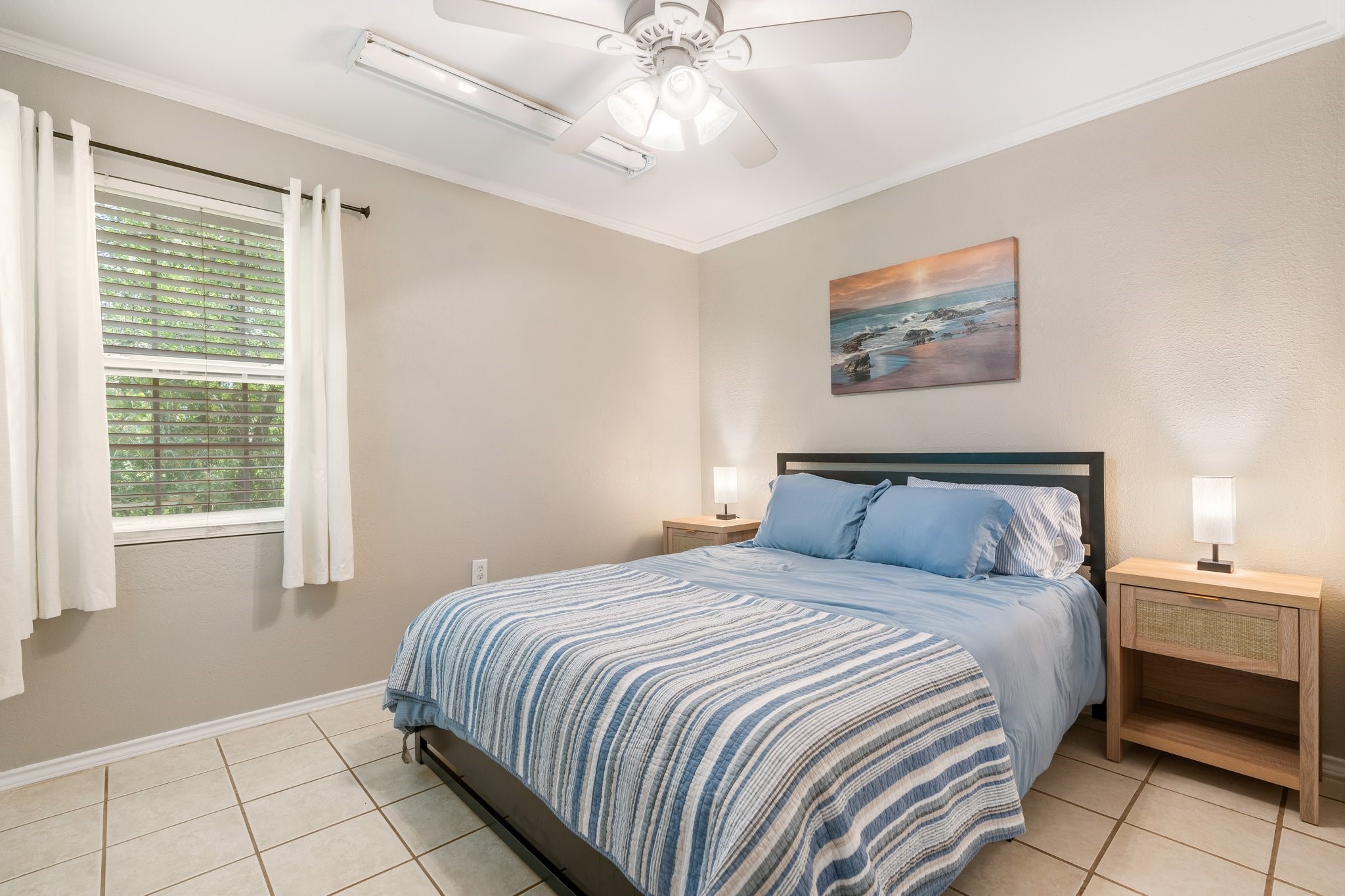 14758 Kirbee Drive Conroe, TX 77302 - Photo 26 of 35 Cozy bedroom with neutral tones, featuring a comfortable bed, tile flooring, ceiling fan, and ample natural light from a window with curtains.