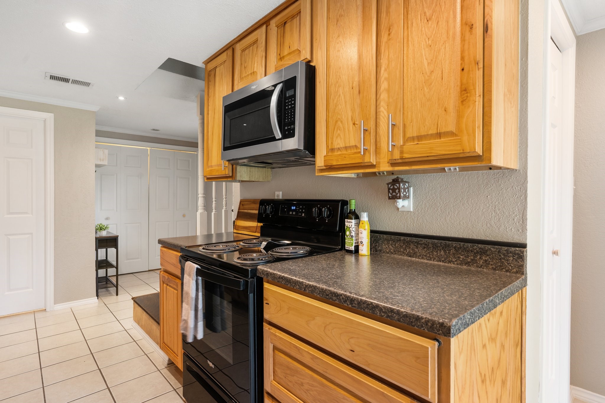 14758 Kirbee Drive Conroe, TX 77302 - Photo 9 of 35 Discover culinary delight in this inviting first-floor kitchen, featuring sleek appliances, warm wooden cabinetry, and ample counter space perfect for creating memorable meals.