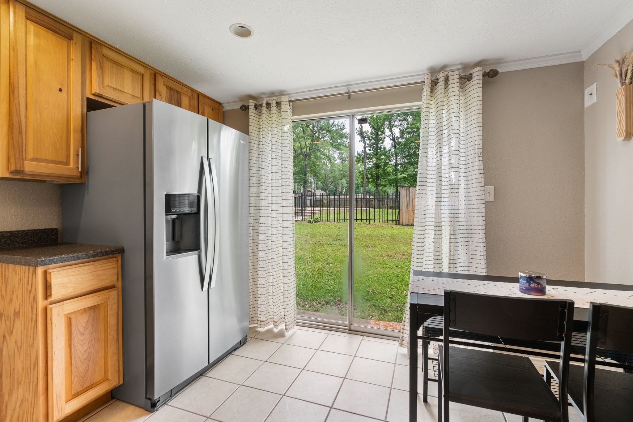 14758 Kirbee Drive Conroe, TX 77302 - Photo 10 of 35 Enjoy a charming breakfast area with additional kitchen cabinets on the first floor, featuring a scenic view through sliding glass doors that bring the outdoors in.