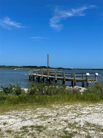 a view of a table and chairs under an umbrella in front of house