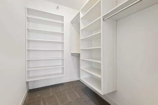 a view of walk in closet with empty racks