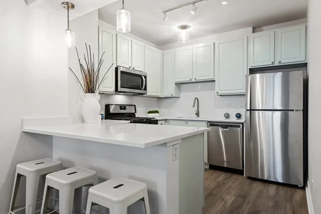 a kitchen with a sink a microwave a refrigerator and cabinets