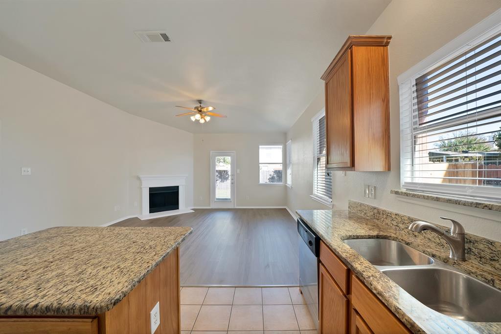 3813 Cane River Road Fort Worth, TX 76244 - Photo 11 of 28 a kitchen with a sink dishwasher and fireplace with wooden floor