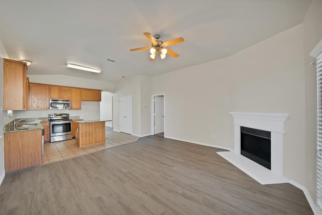 3813 Cane River Road Fort Worth, TX 76244 - Photo 13 of 28 a view of a kitchen with a sink wooden cabinets and a fireplace