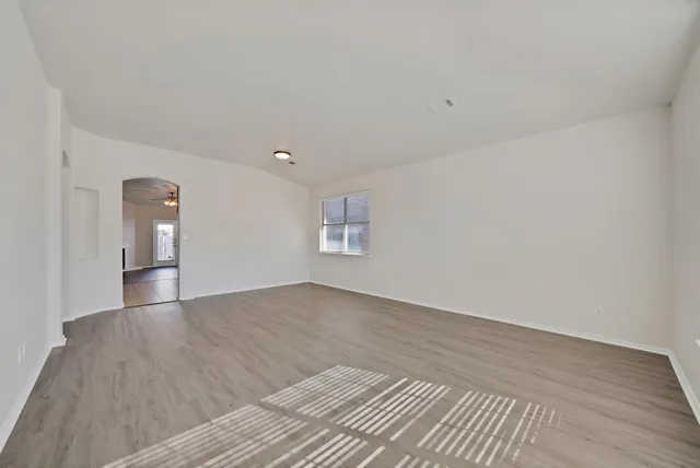 a view of empty room with wooden floor