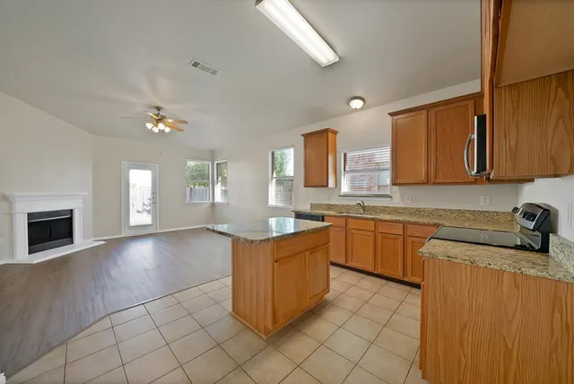 a kitchen with stainless steel appliances granite countertop a sink counter space cabinets and a stove
