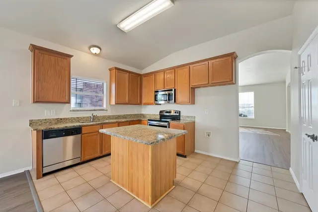 a kitchen with stainless steel appliances granite countertop a stove top oven a sink a counter top space and cabinets