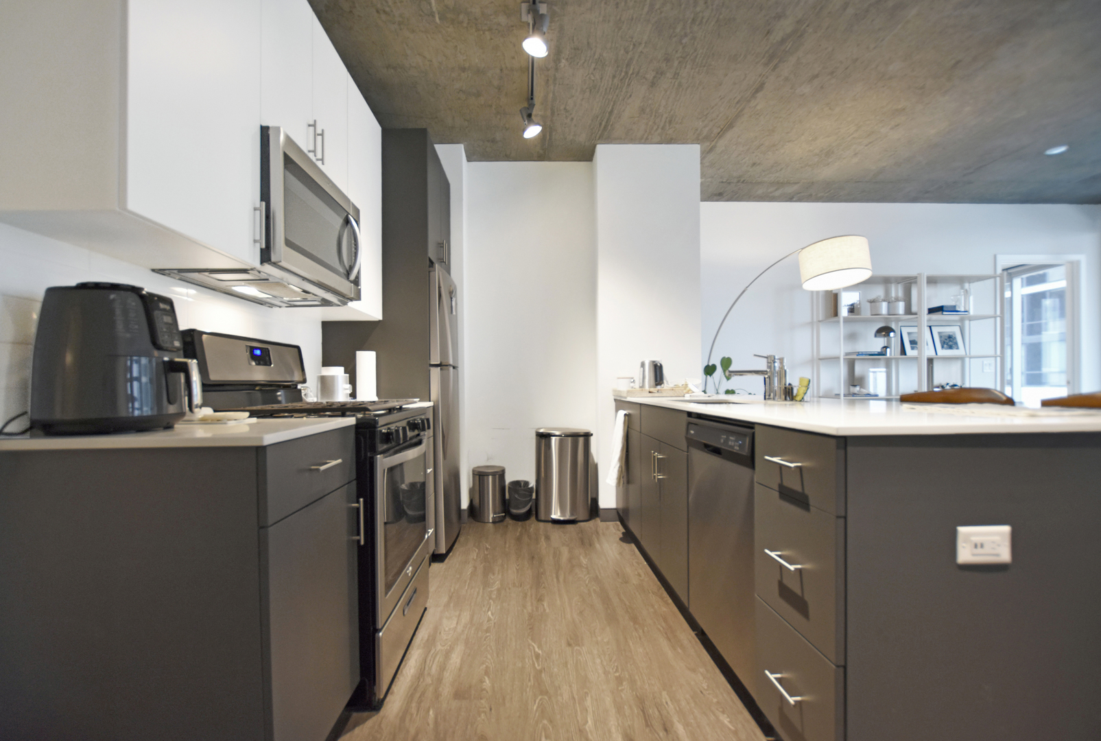 60 East Randolph Street, Unit 1303 Chicago, IL 60601 - Photo 10 of 38 a kitchen with kitchen island granite countertop a sink a counter top space stainless steel appliances and cabinets