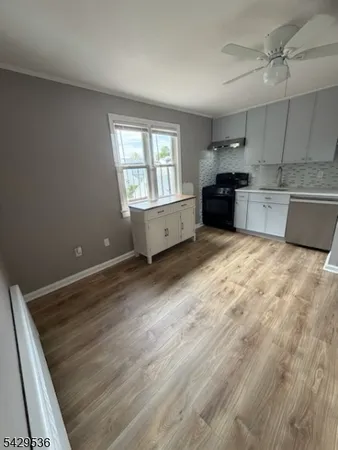a large white kitchen with granite countertop a sink