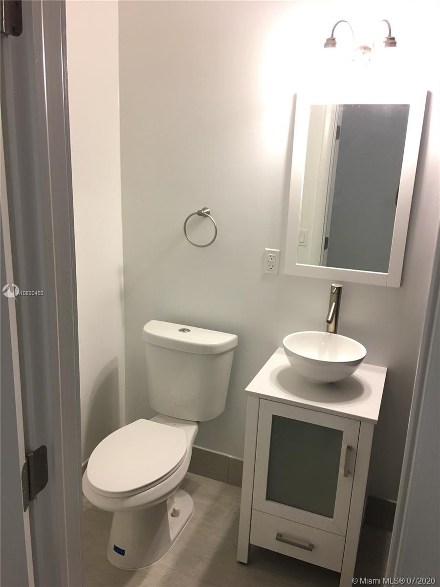310 Southwest 34th Avenue, Unit 310 Miami, FL 33135 - Photo 15 of 18 a bathroom with a granite countertop toilet sink and mirror