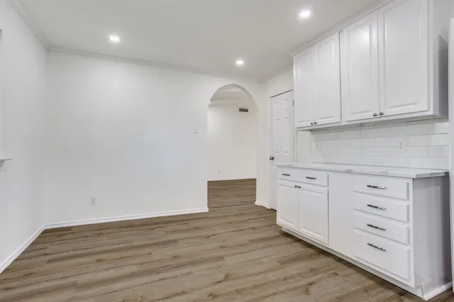 a kitchen with cabinets appliances and a wooden floor