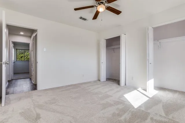 an empty room with fan and entrance