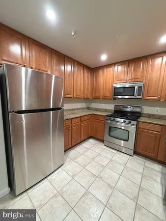 a kitchen with granite countertop a refrigerator and a sink