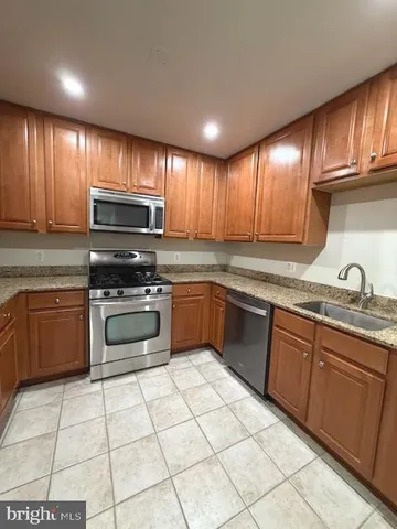a kitchen with a stove sink and cabinets