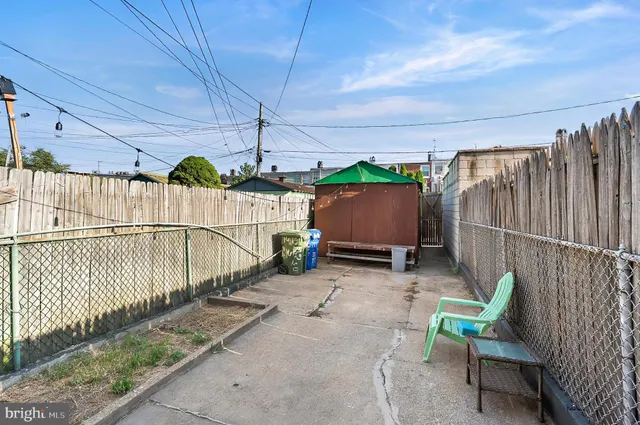 a view of a backyard with wooden floor and iron fence