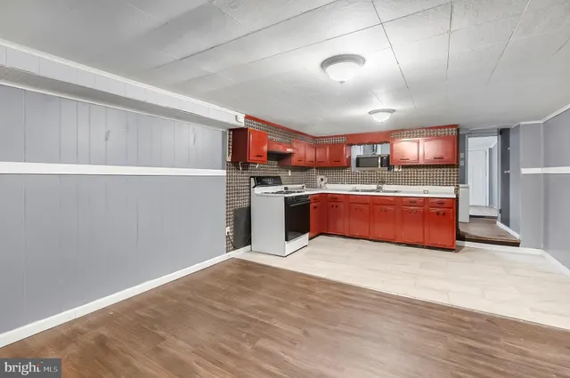 a kitchen with stainless steel appliances granite countertop a sink cabinets and wooden floor