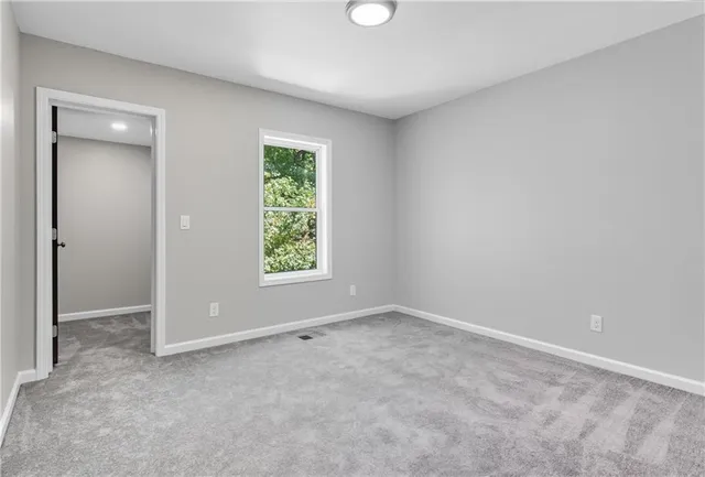 an empty room with windows and closet