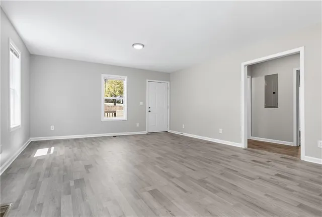 an empty room with wooden floor and windows