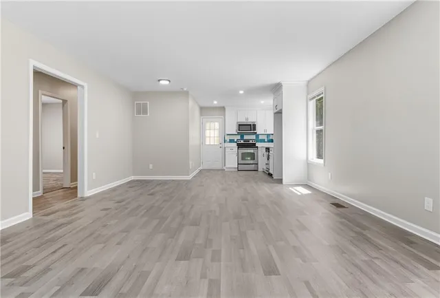 a view of empty room with wooden floor