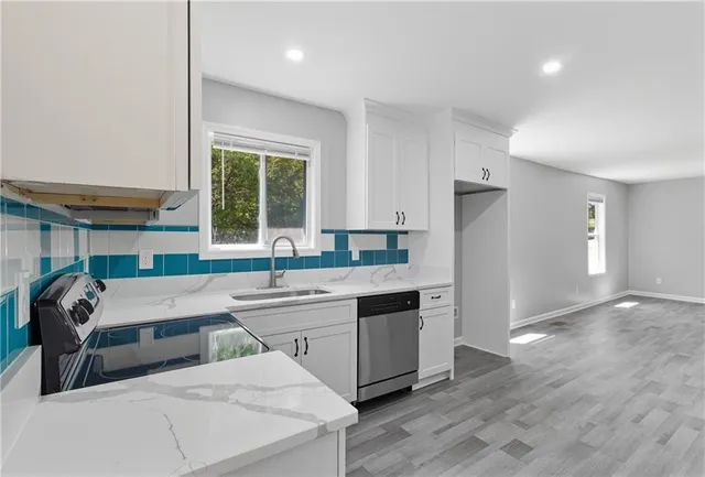 a kitchen with stainless steel appliances granite countertop a sink and cabinets