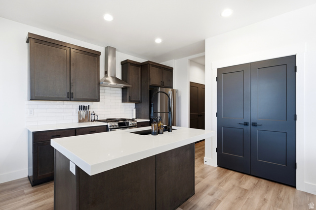 6039 North Westridge Road Heber City, UT 84032 - Photo 12 of 71 Kitchen featuring dark wood-finish cabinetry, white subway tile backsplash, stainless steel appliances, a center island with a white countertop, and wood-finish flooring