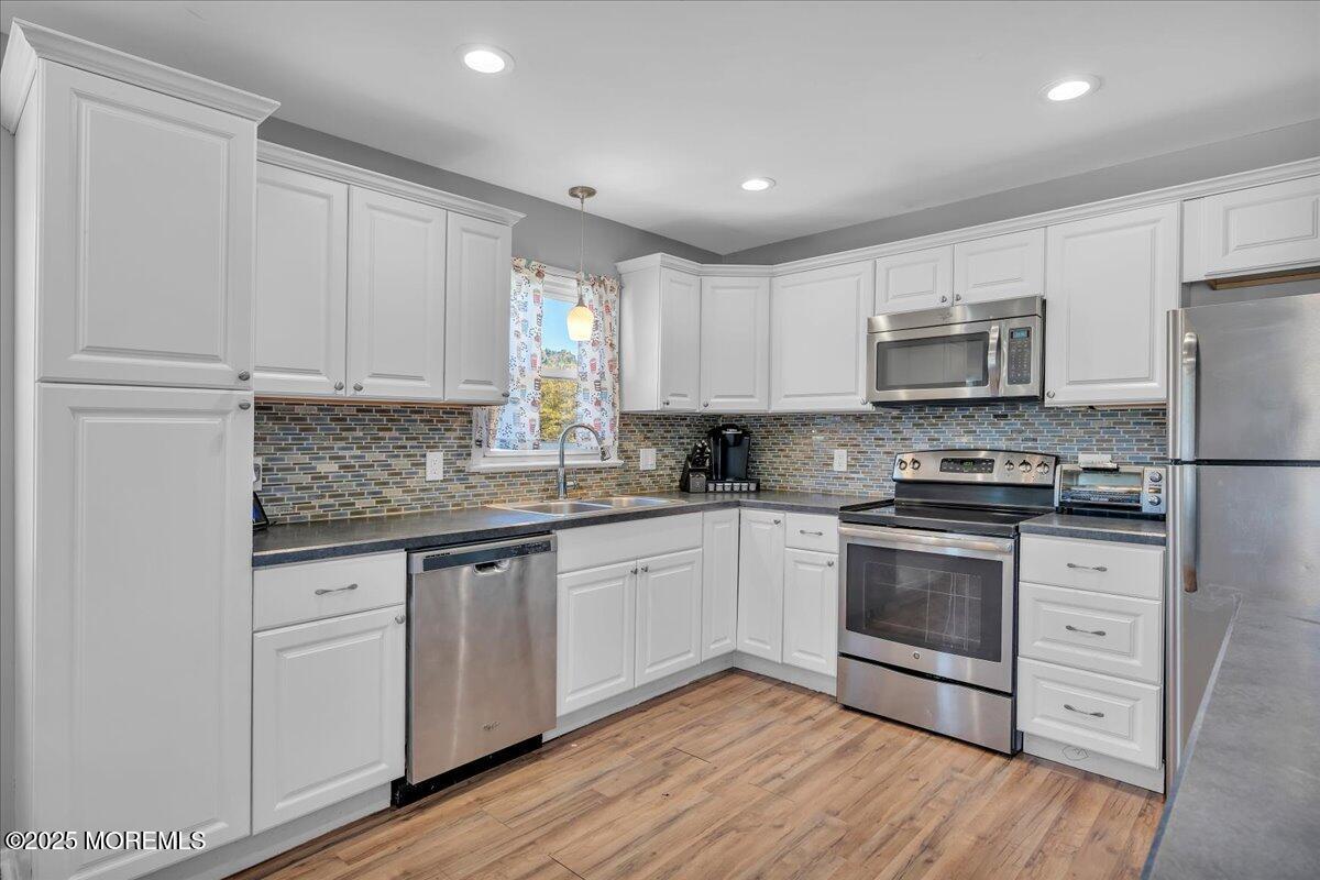 6 Reno Court Barnegat, NJ 08005 - Photo 10 of 35 a kitchen with granite countertop white cabinets stainless steel appliances and wooden floor
