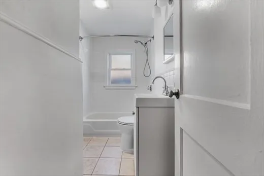 a bathroom with a granite countertop sink mirror vanity and toilet