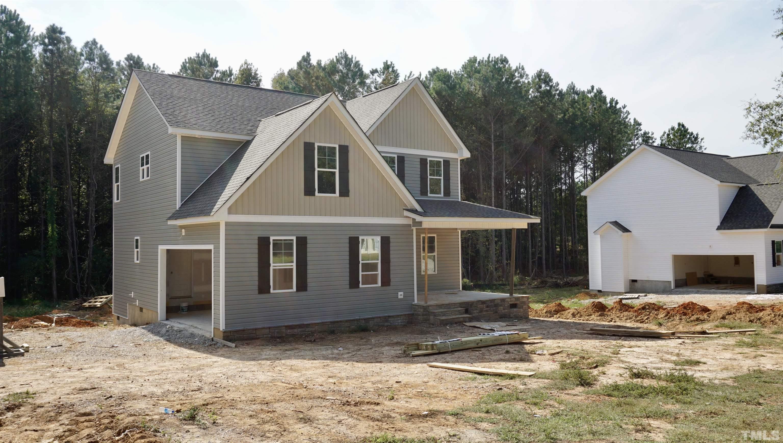 830 Mulberry Road Spring Hope, NC 27882 - Photo 5 of 18 a view of a white house with a large tree and plants
