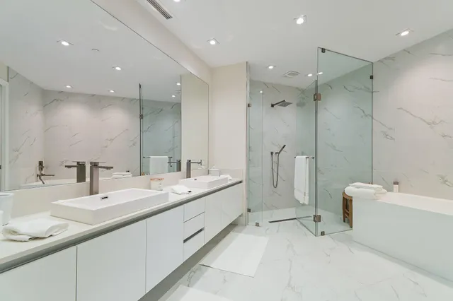 a bathroom with a double vanity sink mirror and shower
