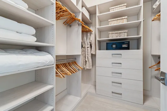 a view of walk in closet with clothes and shoes
