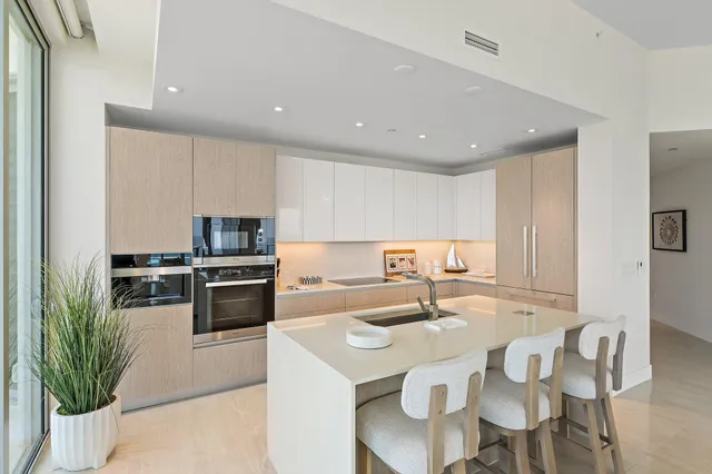 a kitchen with stainless steel appliances kitchen island granite countertop a sink and cabinets