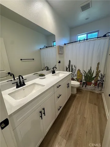 a spacious bathroom with a double vanity sink a mirror and a shower