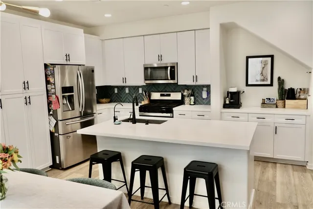 a kitchen with stainless steel appliances a stove refrigerator sink and cabinets