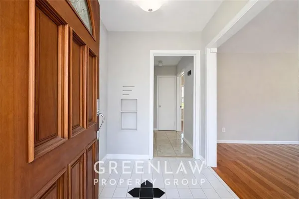 a view of a hallway with wooden floor and a bathroom