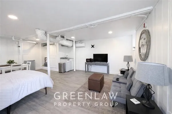 a spacious bedroom with a bed a mirror and a flat tv screen