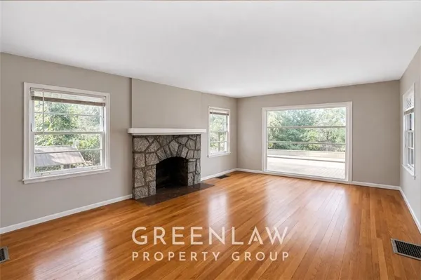 a view of empty room with wooden floor and fireplace